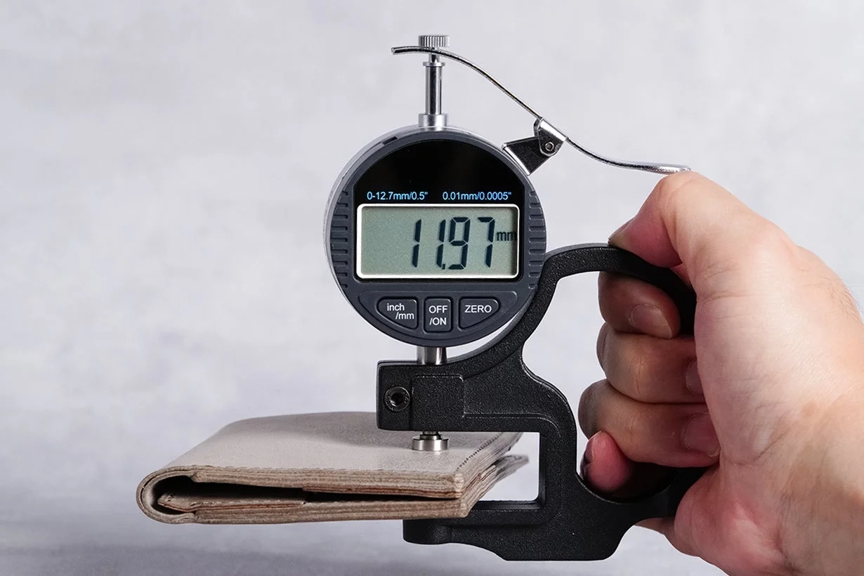デジタルシックネスゲージで革のような素材の厚みを測定している様子