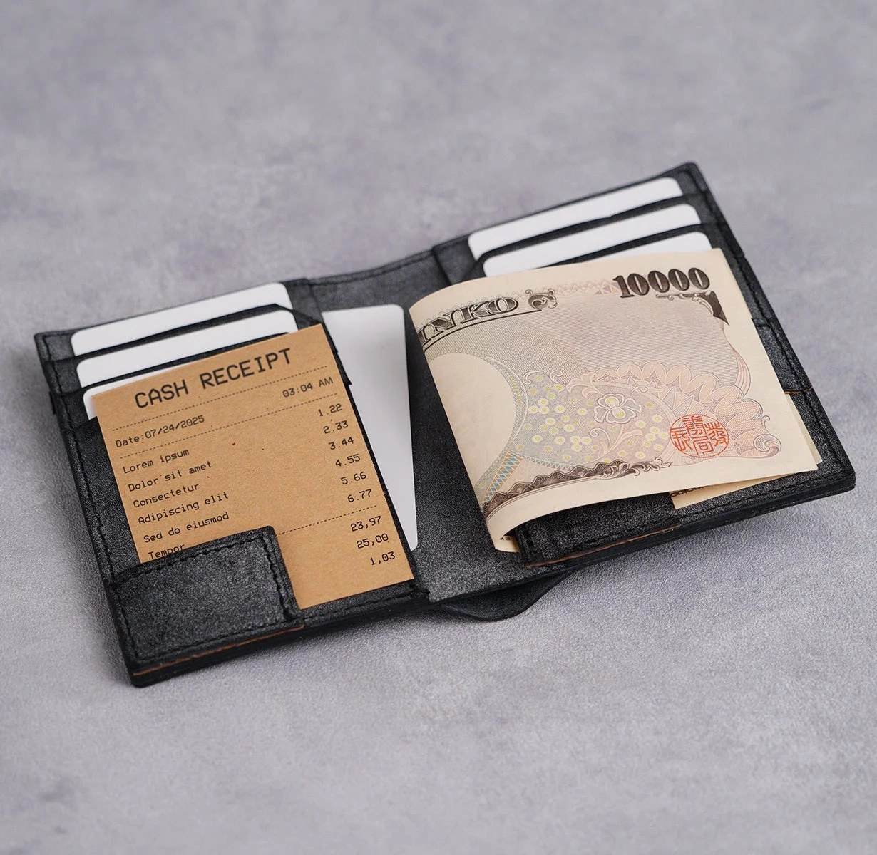 黒い財布が開かれており、中に日本の10000円札、キャッシュレシート、そして数枚のカードが収納されている様子