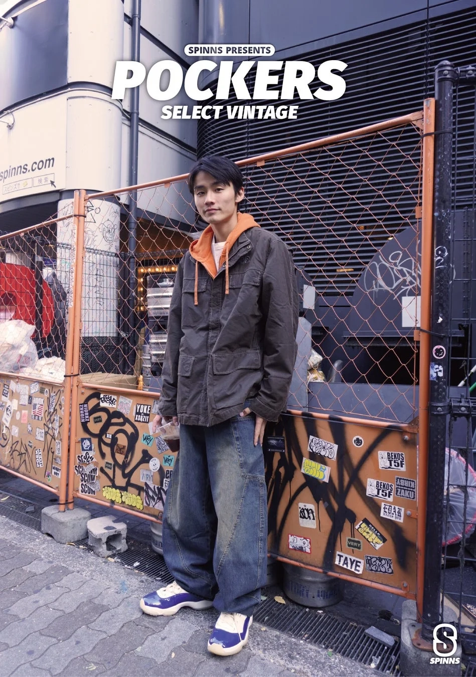 フェンス前でポーズをとる男性