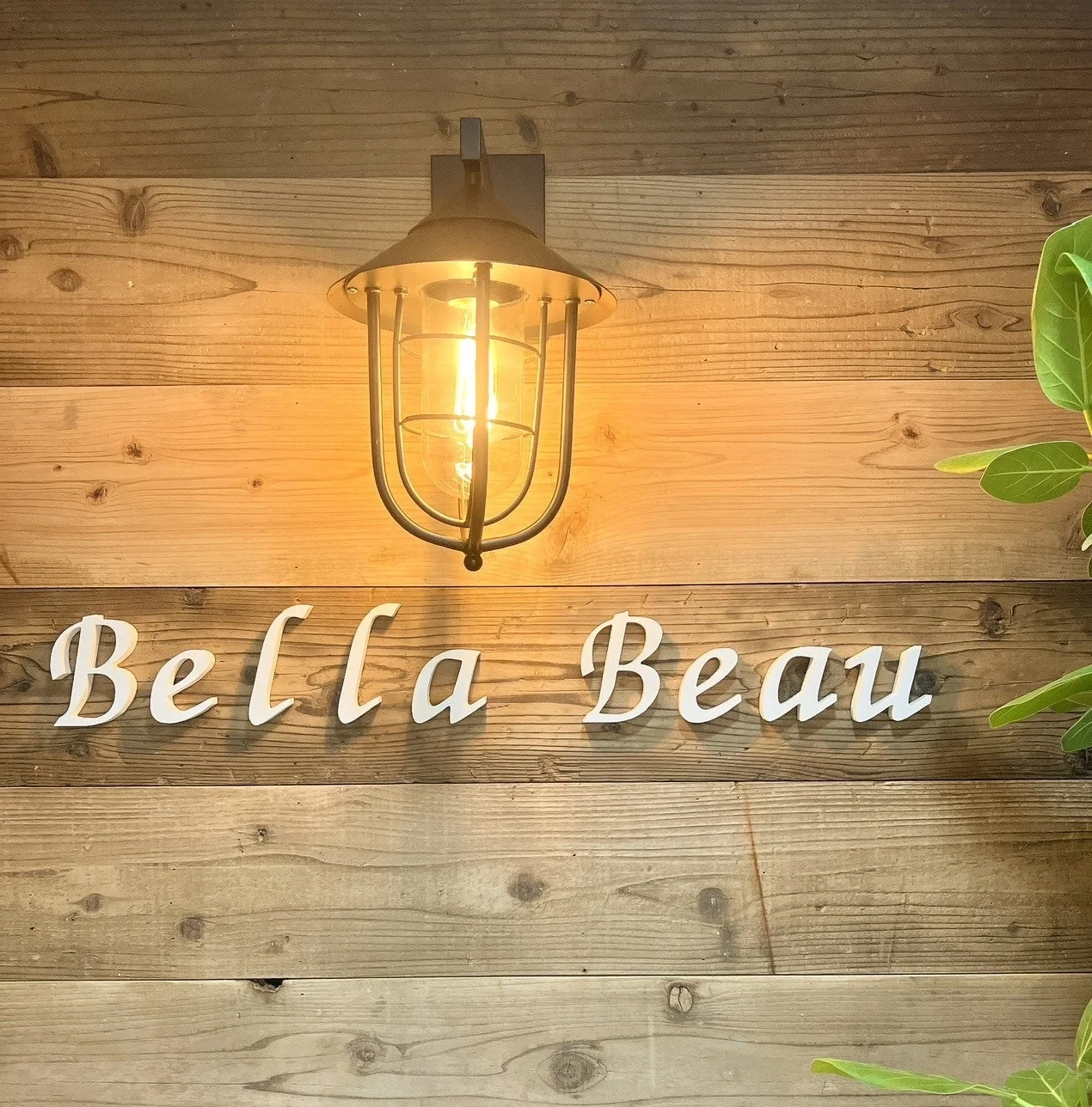 Bella Beauのロゴと木目調の壁